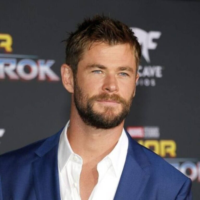 Chris Hemsworth attends the Thor premiere dressed in a blue suit and showcasing his classic mohawk haircut.