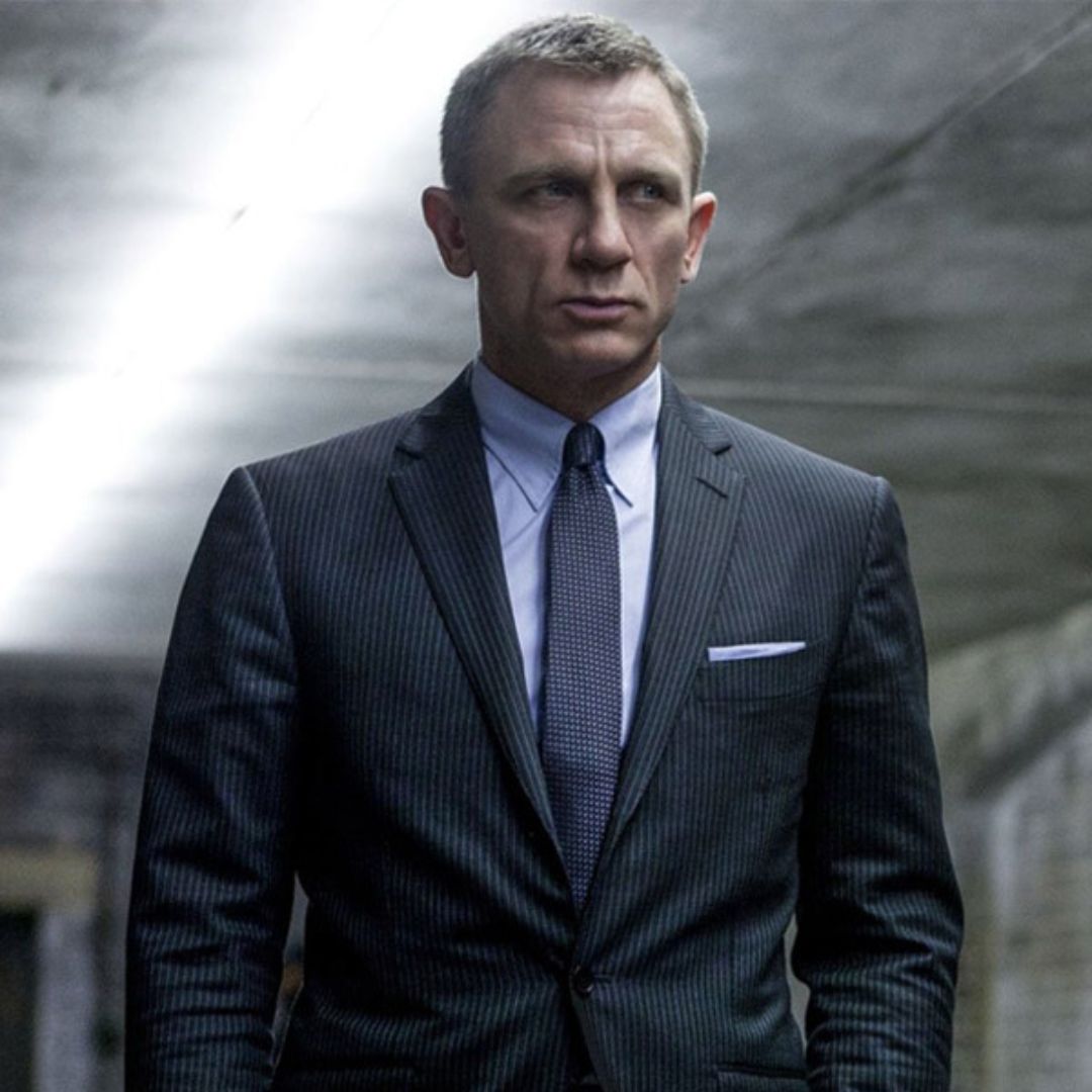 In the film "Skyfall," Daniel Craig captivates audiences with his timeless style, seen here donning a black/grey stripe suit that perfectly matches his classic Caesar haircut, showcasing his impeccable sense of sophistication.