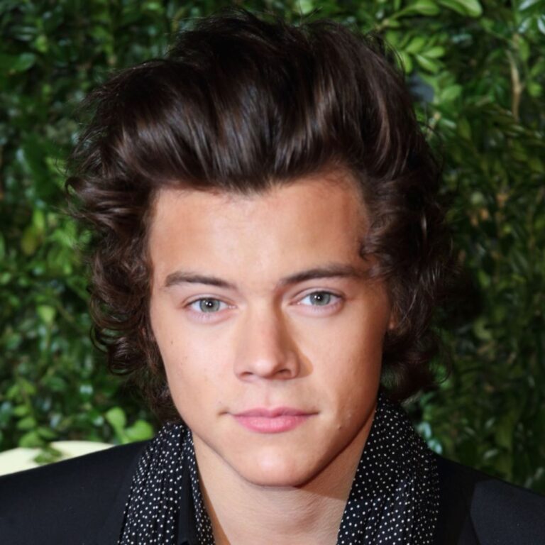 Harry Styles is gazing directly at the camera, sporting a slick back hairstyle.