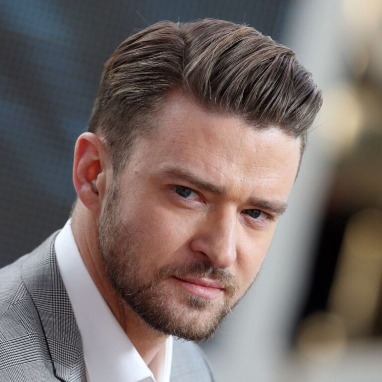 With a captivating gaze directed at the camera, Justin Timberlake exudes sophistication, sporting a suave side part haircut. Dressed in a sharp grey suit and crisp white shirt, his impeccable style complements his confident and polished persona.