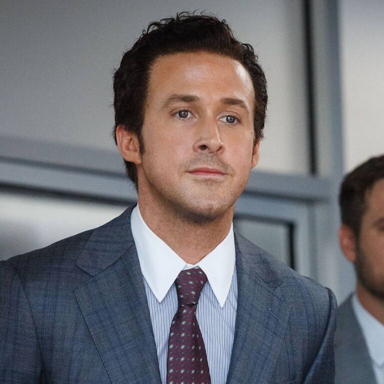In this scene from "The Big Short," Ryan Gosling sports a messy slicked-back hairstyle that adds a touch of modern sophistication to his overall appearance, perfectly complementing his portrayal of the savvy and ambitious Wall Street broker, Jared Vennett.