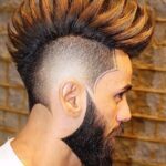 An Arab man with a dyed spiky mohawk haircut.