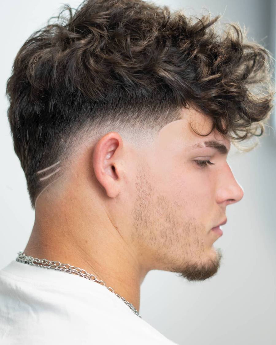 A man sporting a taper fade with curly hair, exemplifying a contemporary and fashionable hairstyle.