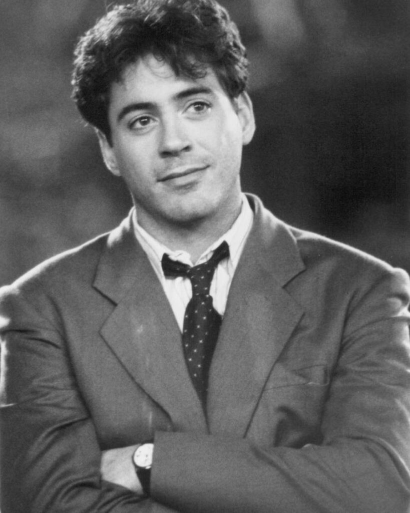 A well-dressed man in a suit and tie showcases his neat haircut while posing for a formal photograph.