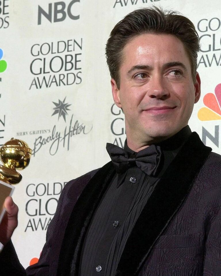 Robert Downey Jr. celebrates winning the Golden Globe for Best Actor in a Drama, showcasing his stylish haircut.