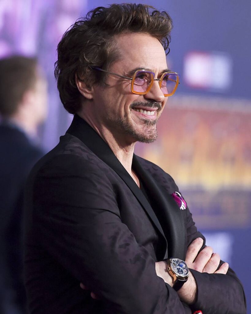 Robert Downey Jr. as Iron Man, showcasing a stylish haircut and his iconic armored suit in a dynamic pose.